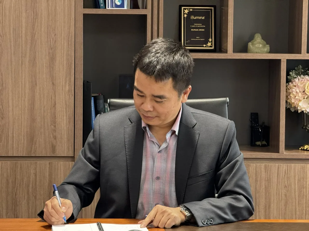 Binh Ba Ngo signing documents at his office
